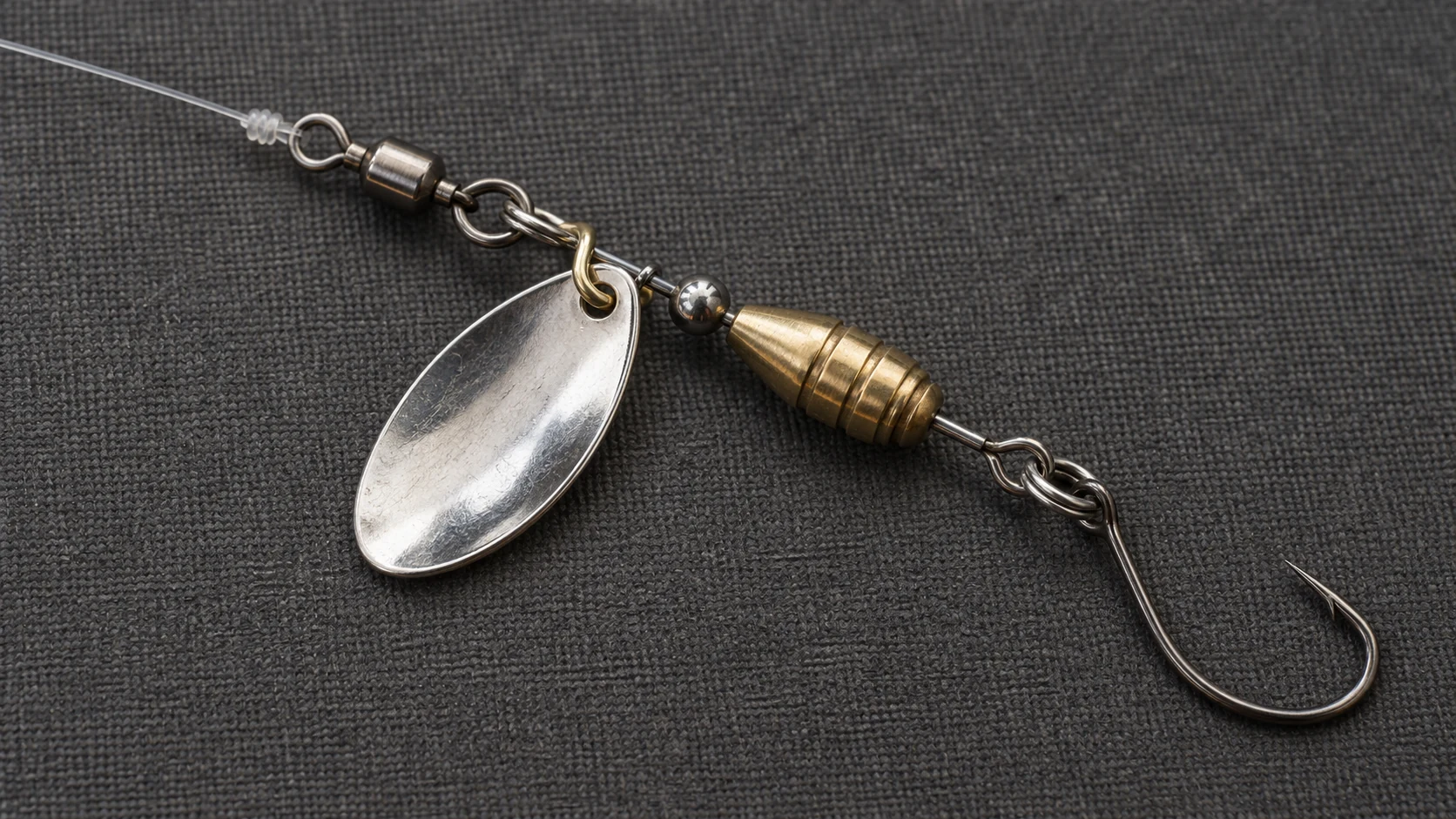 Kleiner Spinner mit silbernem Blatt, Messingkörper, Einzelhaken und vorgeschaltetem Wirbel an Monofilschnur